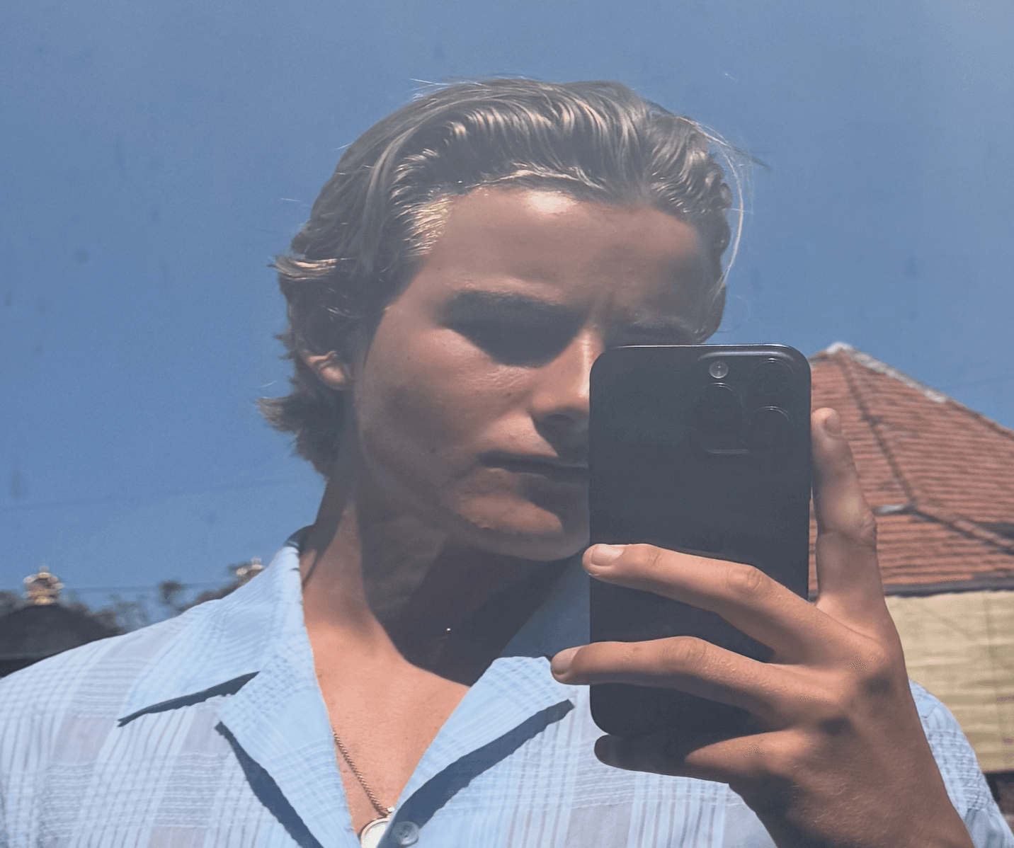 After: sharper, more defined jawline and cheekbones in a mirror selfie